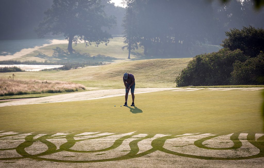 一个高尔夫球手在一个风景优美的高尔夫球场上打球。