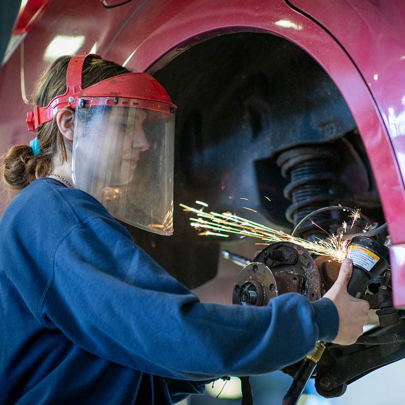 A student works on a car wheel.