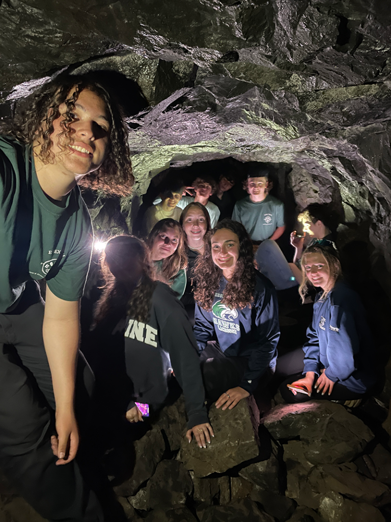 学生们在 Lynnwoods 的 Dungeon Rock 洞穴中合影留念。