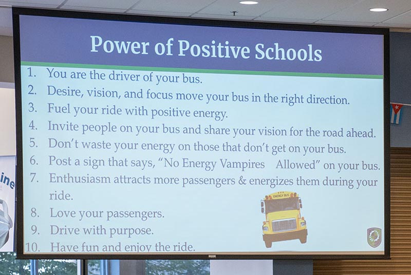 Ein Bildschirm, auf dem eine Folie mit dem Titel „Poser of Positive Schools“ zu sehen ist.