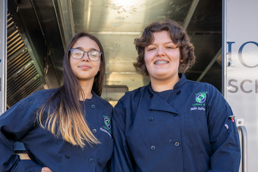 Alunos de artes culinárias distribuindo biscoitos do food truck na visitação pública anual.