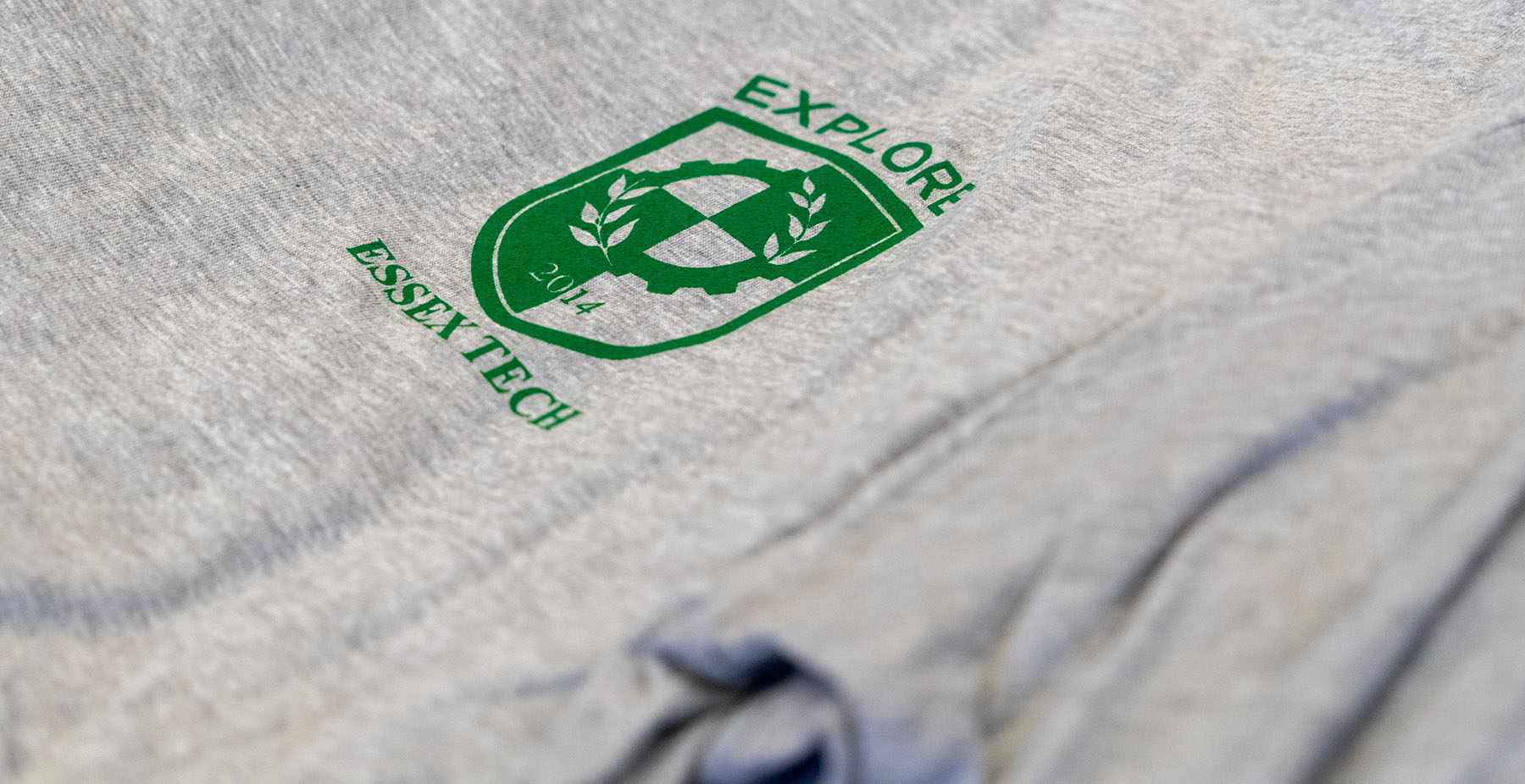 Camiseta con estampado del logo del colegio y la palabra "explorar".