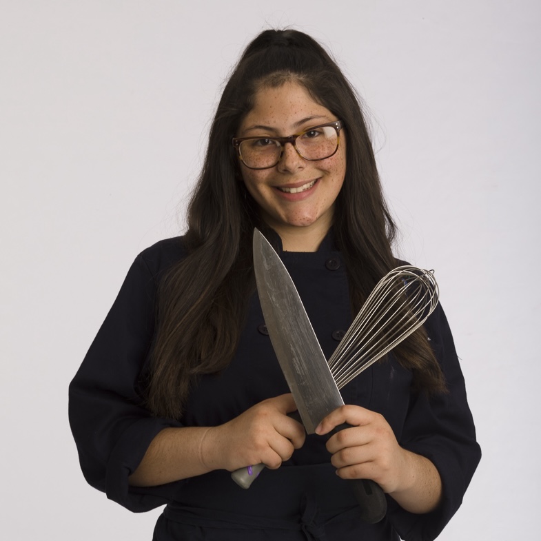 Estudante segurando uma faca de cozinha e um batedor
